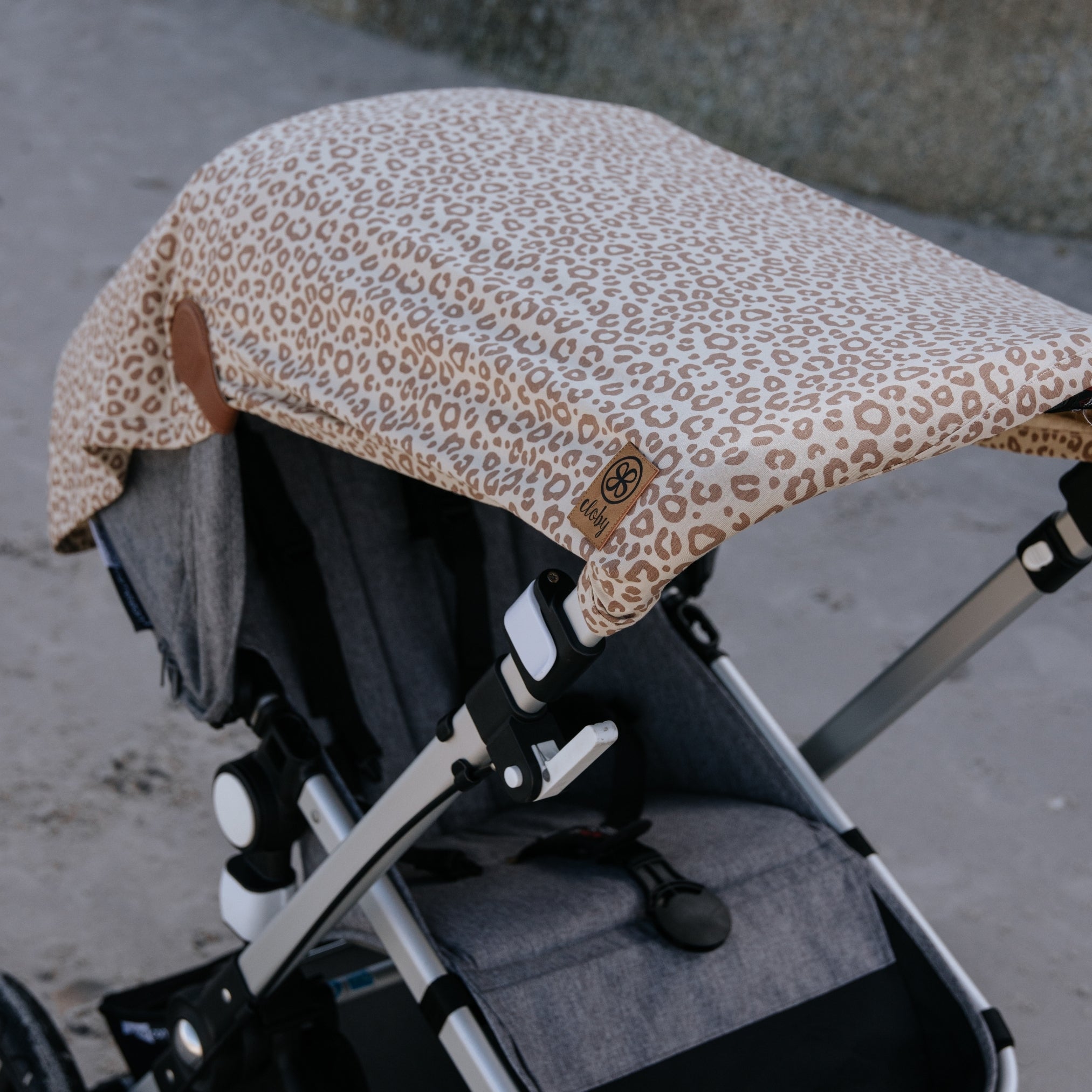Zonbeschermingsdoek over kinderwagen in luipaard print